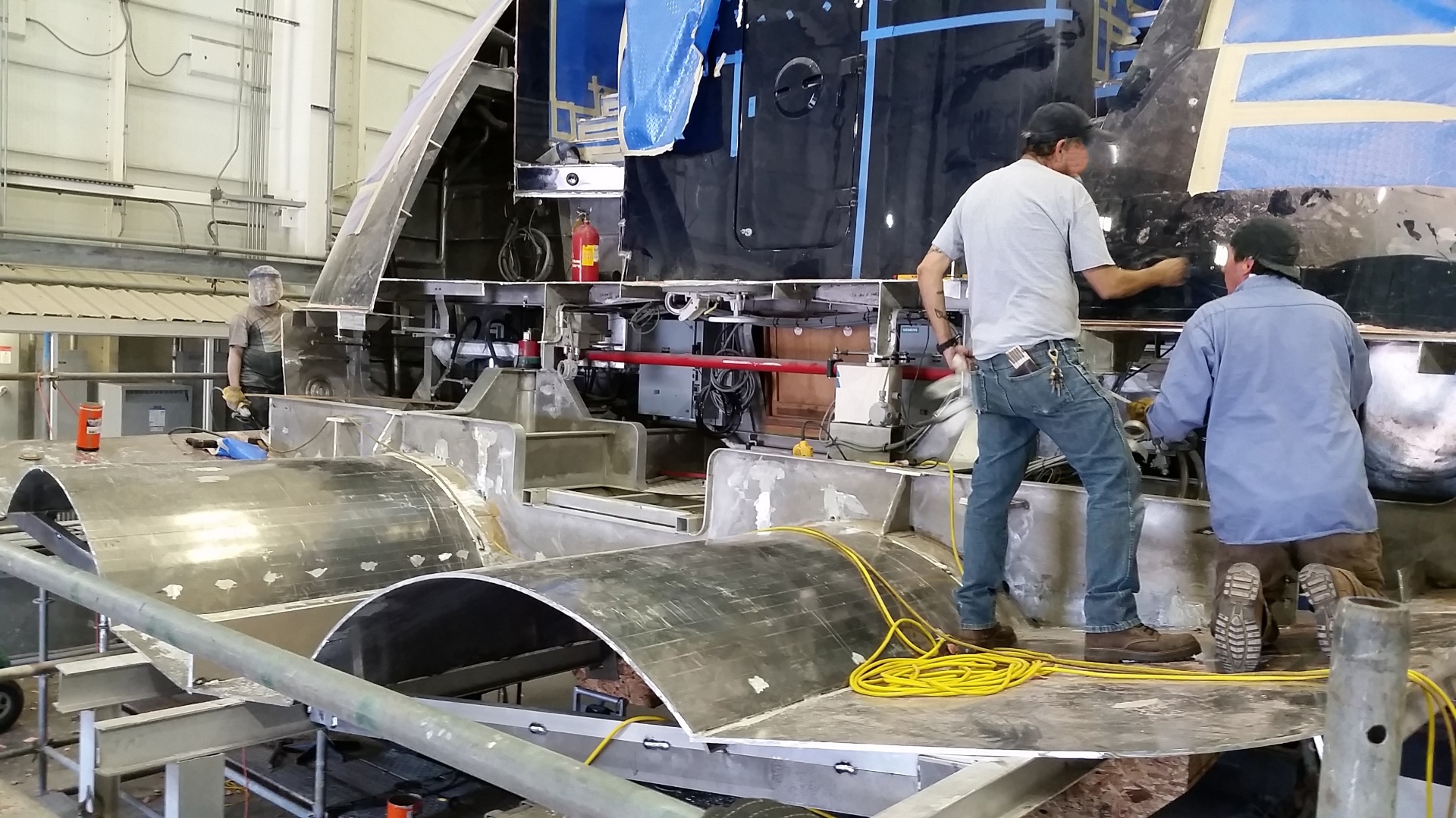 Crew working on a yacht structure inside Thunderbolt Marine during an extensive refit.