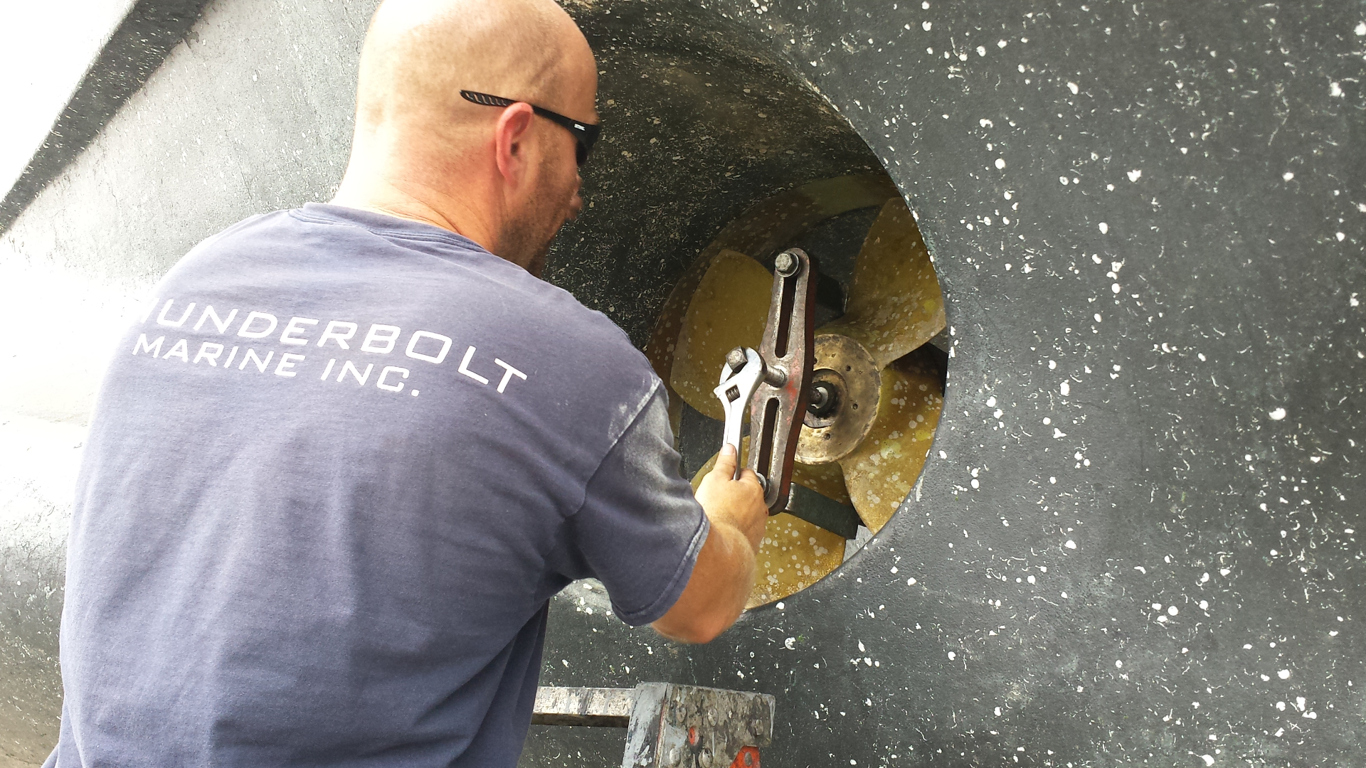 Technician servicing a yacht bow thruster with a wrench at Thunderbolt Marine.